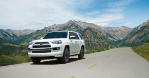 A white Toyota 4Runner driving thought the mountains.
