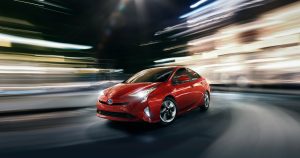 A red 2019 Toyota Prius taking a fast corner.