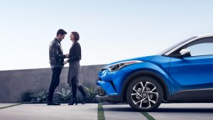 A couple standing outside their 2019 Toyota CH-R.
