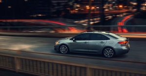 A silver 2020 Toyota Corolla driving down the freeway at night.