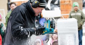 John Benson creating an ice sculpture with a chain saw during the Madison Winter Festival.
