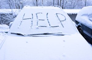 snow covered vehicle with the word "help" written across windshield
