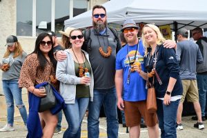 Group of adults with local brews, bacon & cheese.