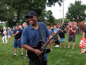 Man playing electric guitar at local summer festival