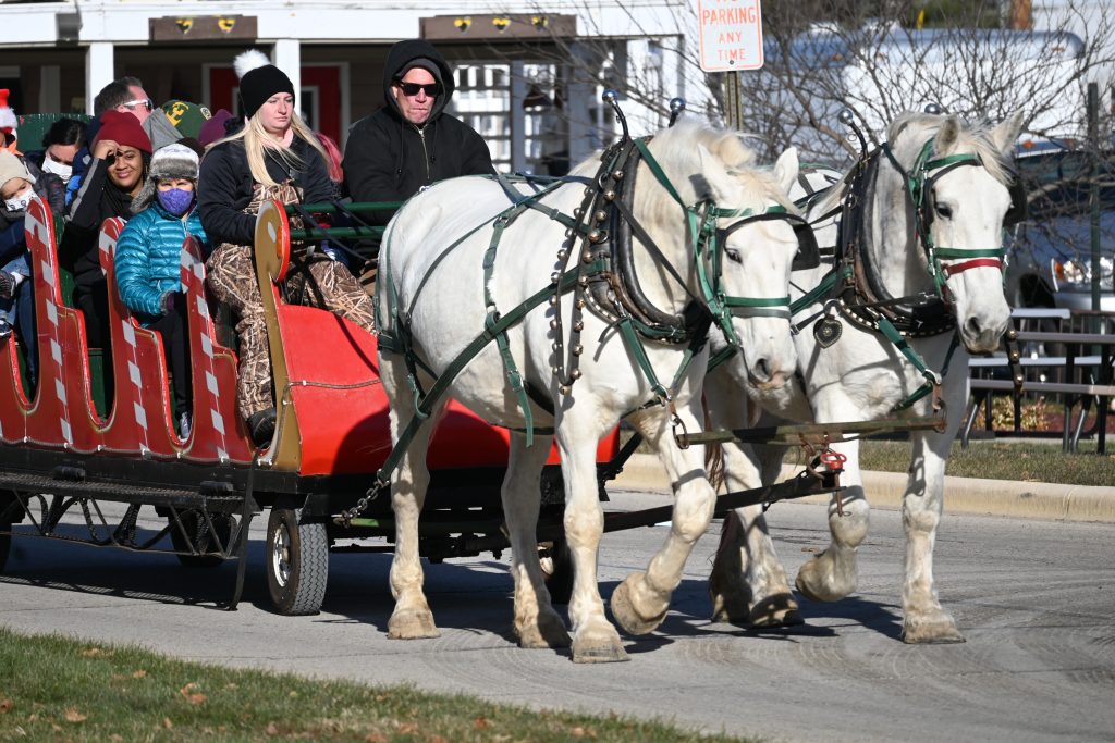 Horse drawn slay with adults and children riding.