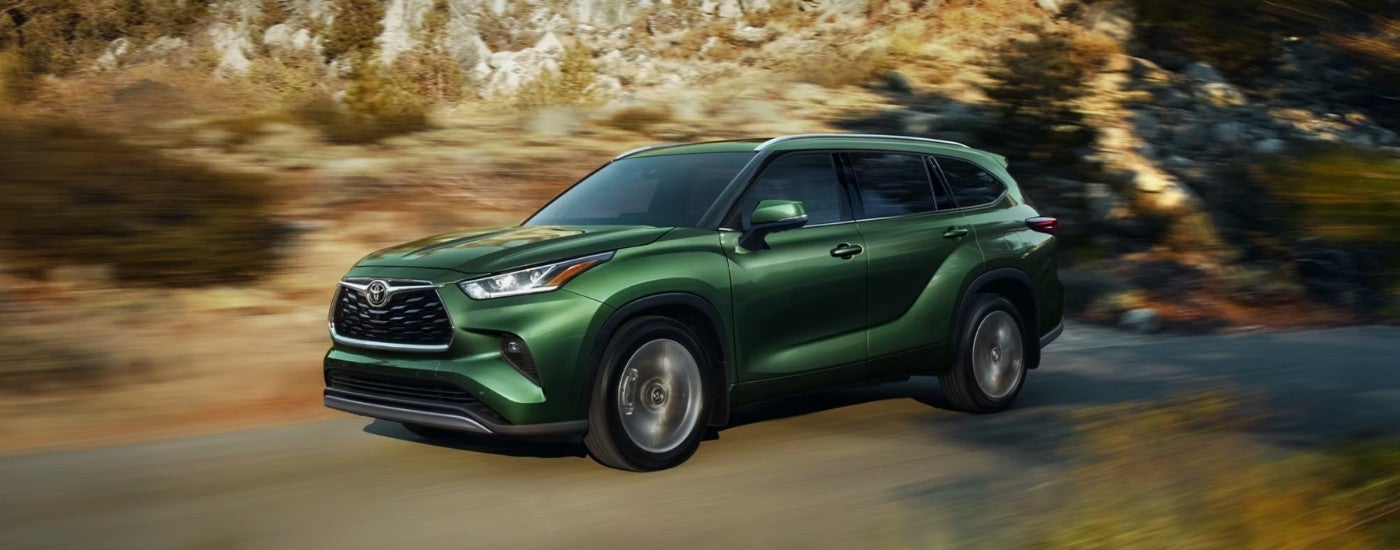 A green 2025 Toyota Highlander for sale from the side.