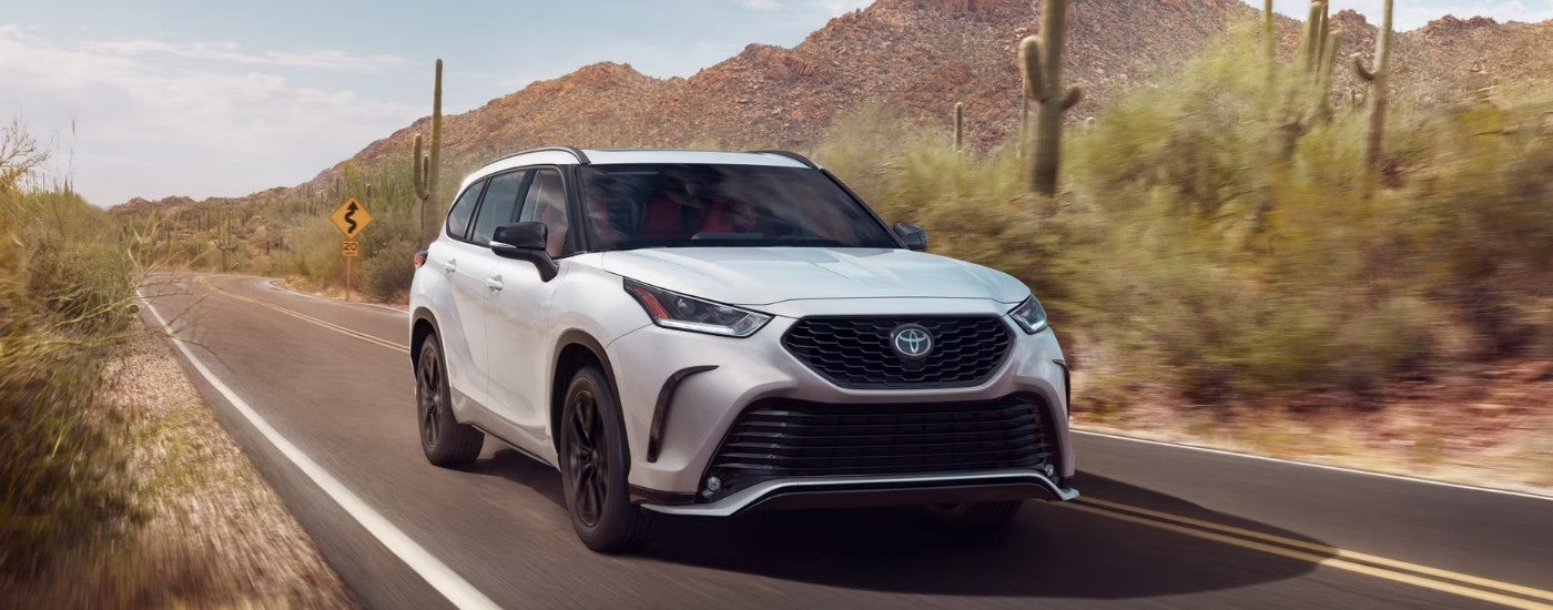 A white 2025 Toyota Highlander from the front at an angle.