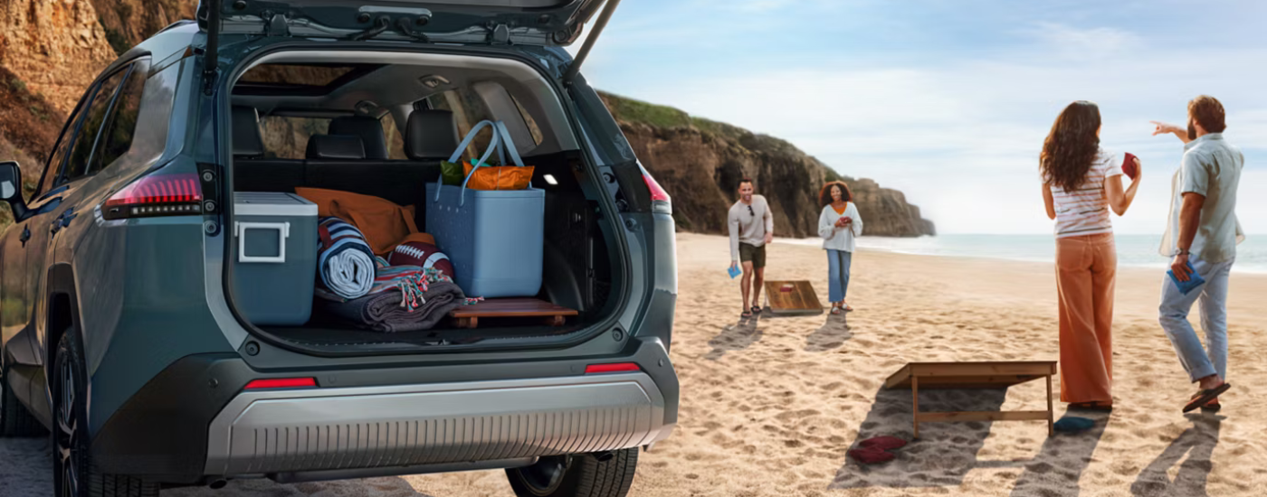 Blue 2026 Toyota RAV4 parked on the beach with a full trunk