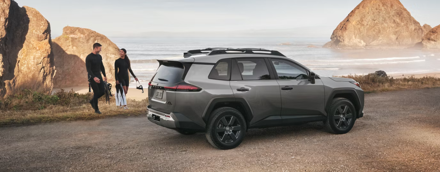 Grey 2026 Toyota RAV4 parked at an angle in front of the ocean