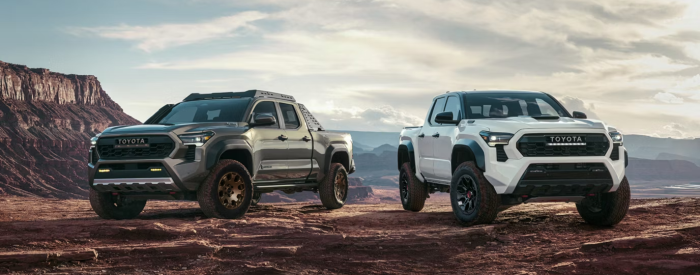 A green 2026 Toyota Tacoma Trail Hunter next to a white 2026 Toyota Tacoma TRD Pro