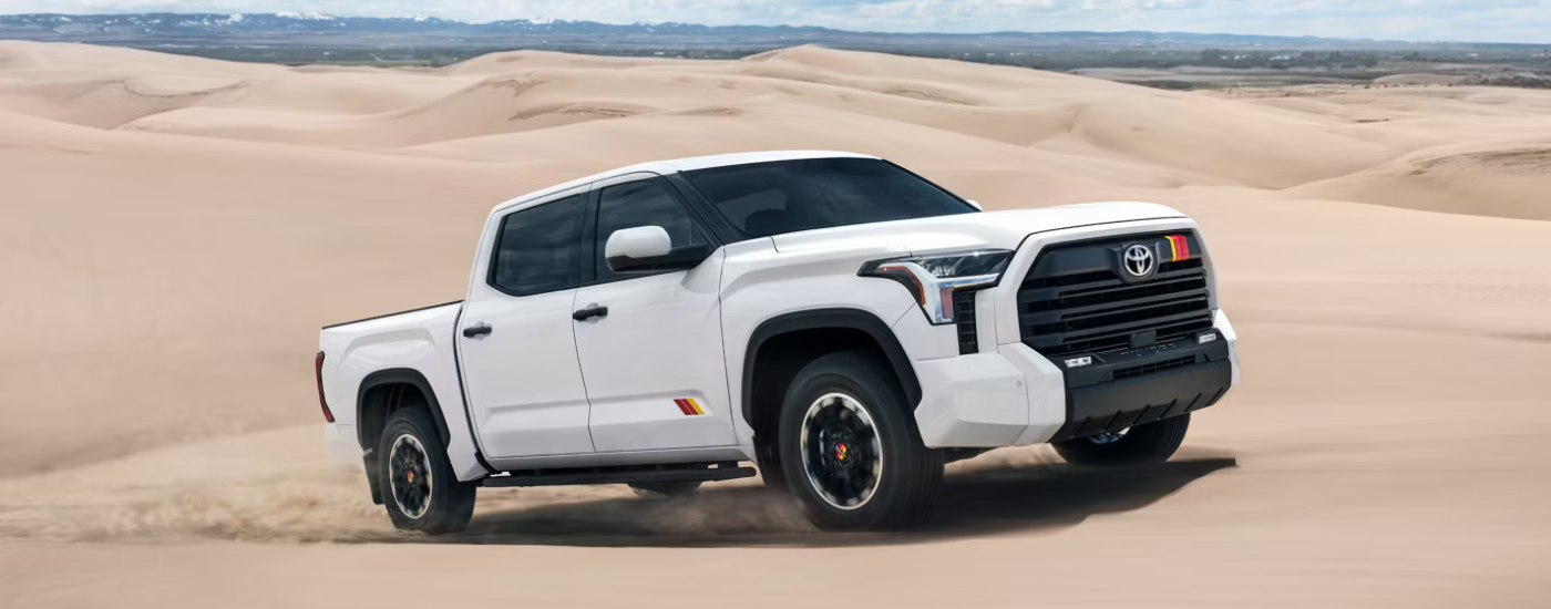 White 2026 Toyota Tundra Rally Edition driving through sand dunes