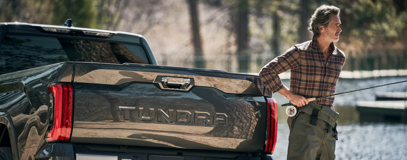 Bed of a black 2026 Toyota Tundra with a person with a fishing rod
