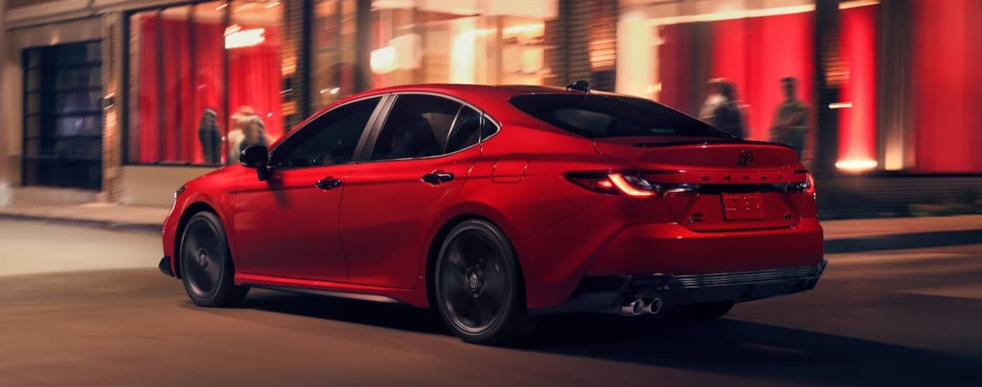 A red 2026 Toyota Camry driving in a city.