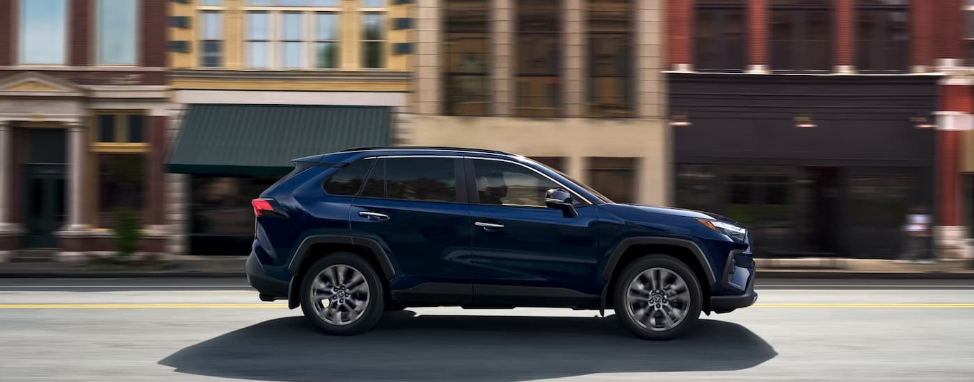 Blue 2025 Toyota RAV4 driving through a city