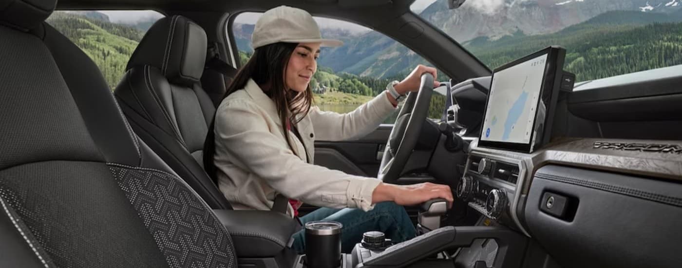 A person driving in a 2025 Toyota Tacoma.