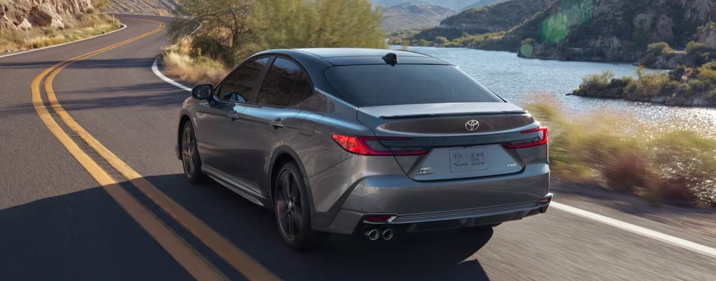 A silver 2025 Toyota Camry driving to a Toyota dealer near Janesville.