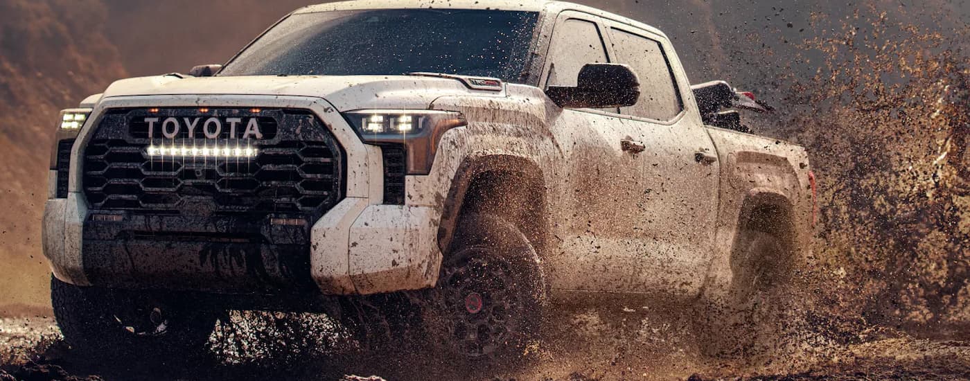 A white 2026 Toyota Tundra off-roading in mud