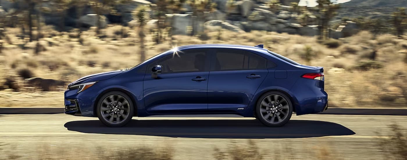 A blue 2026 Toyota Corolla driving down a road